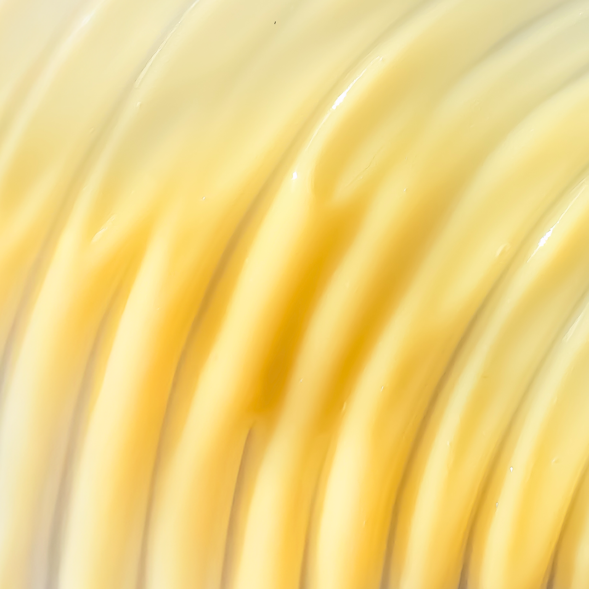 Macro Shot von dem Serum in Wellenform-Textur, die gelb ist