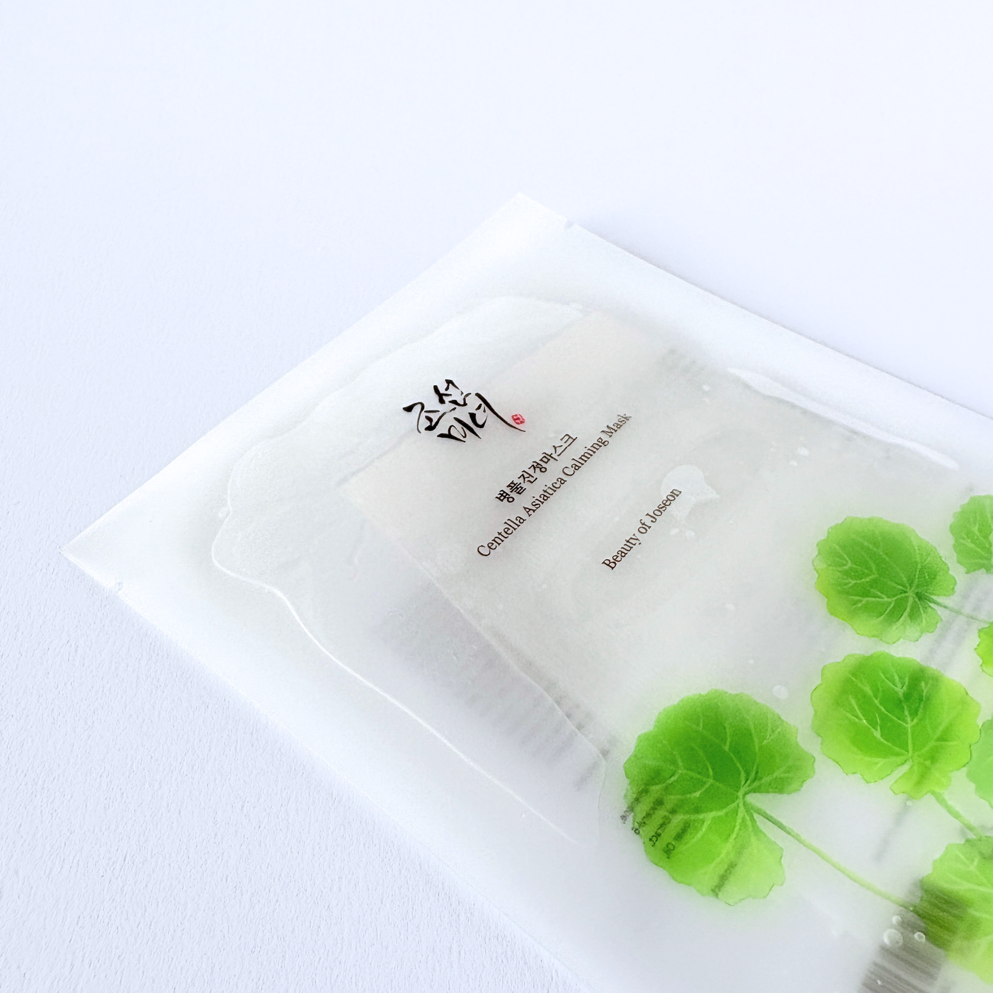 Beauty of Joseon Centella Asiatica Calming Mask liegend mit sichtbar feuchtem Sheet in der Verpackung